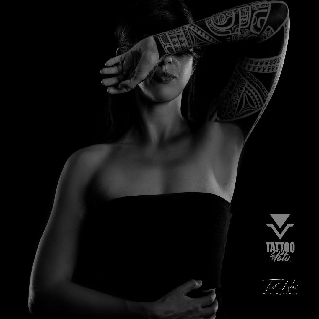 Bras entièrement tatoué de motifs polynésiens, portrait en noir et blanc